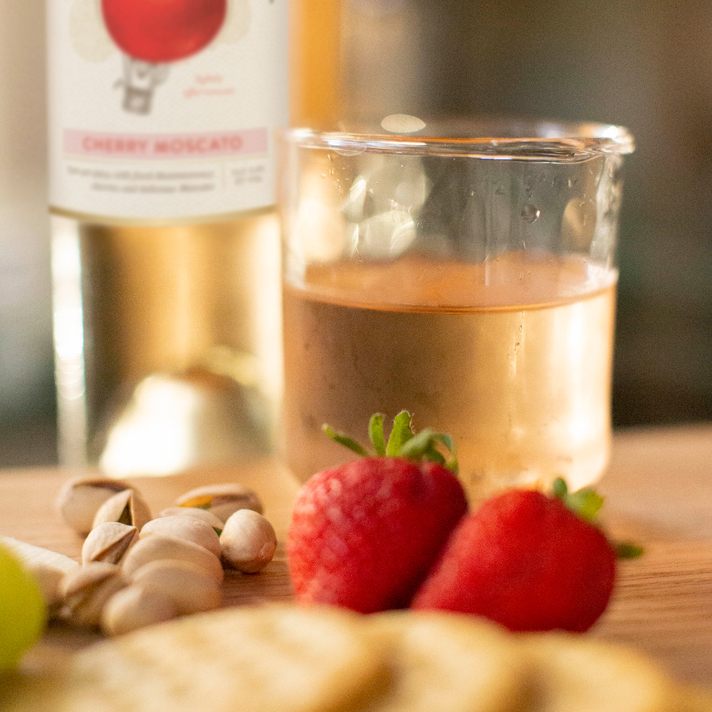 Cherry Moscato in short glass with strawberries and crackers