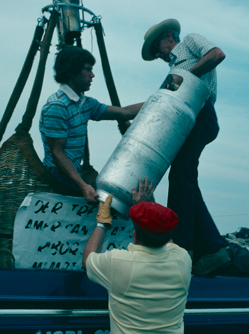 Bill Oliver and fellow balloonists load fuel tin a basket in Peru, Indiana in 1976