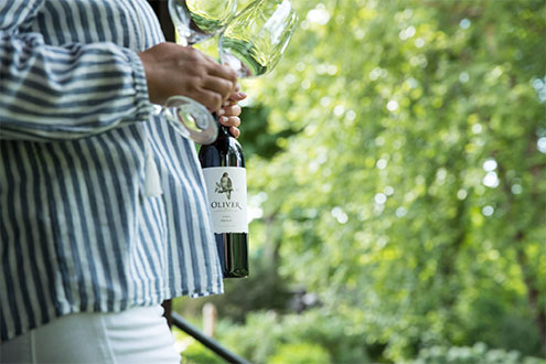 A woman prepares to serve a bottle of dry red wine