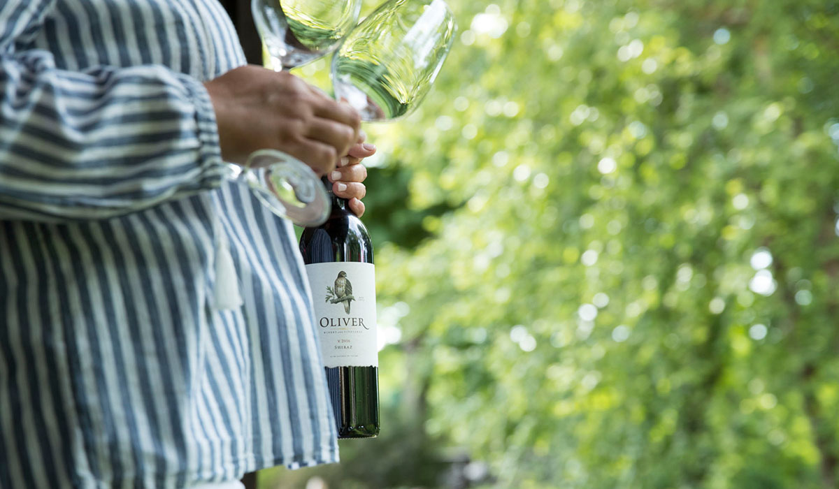 A woman prepares to serve a bottle of dry red wine