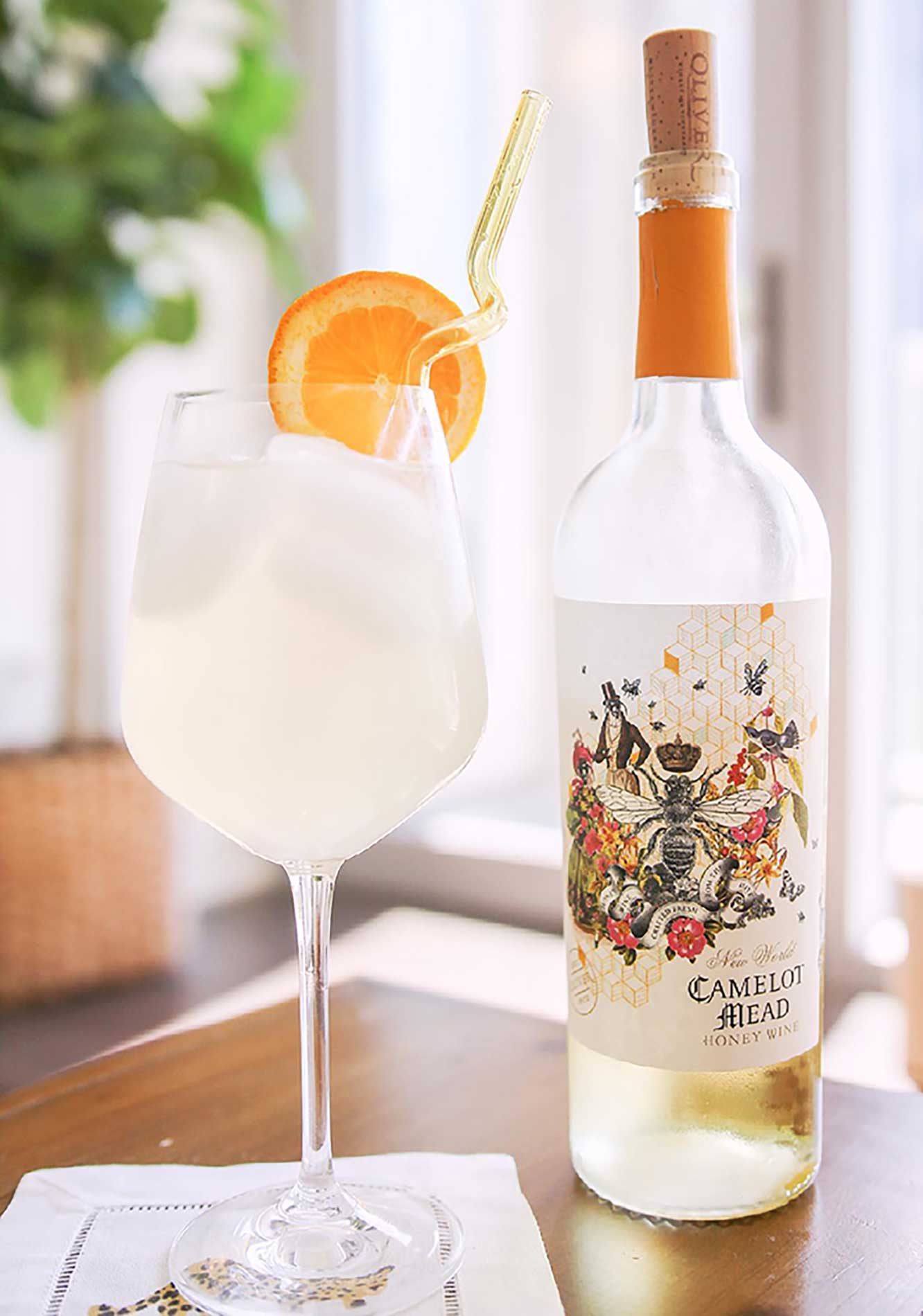 Camelot Mead Wine Cocktail, the Camelot Spritz in a wine glass, with a glass straw and slice of orange