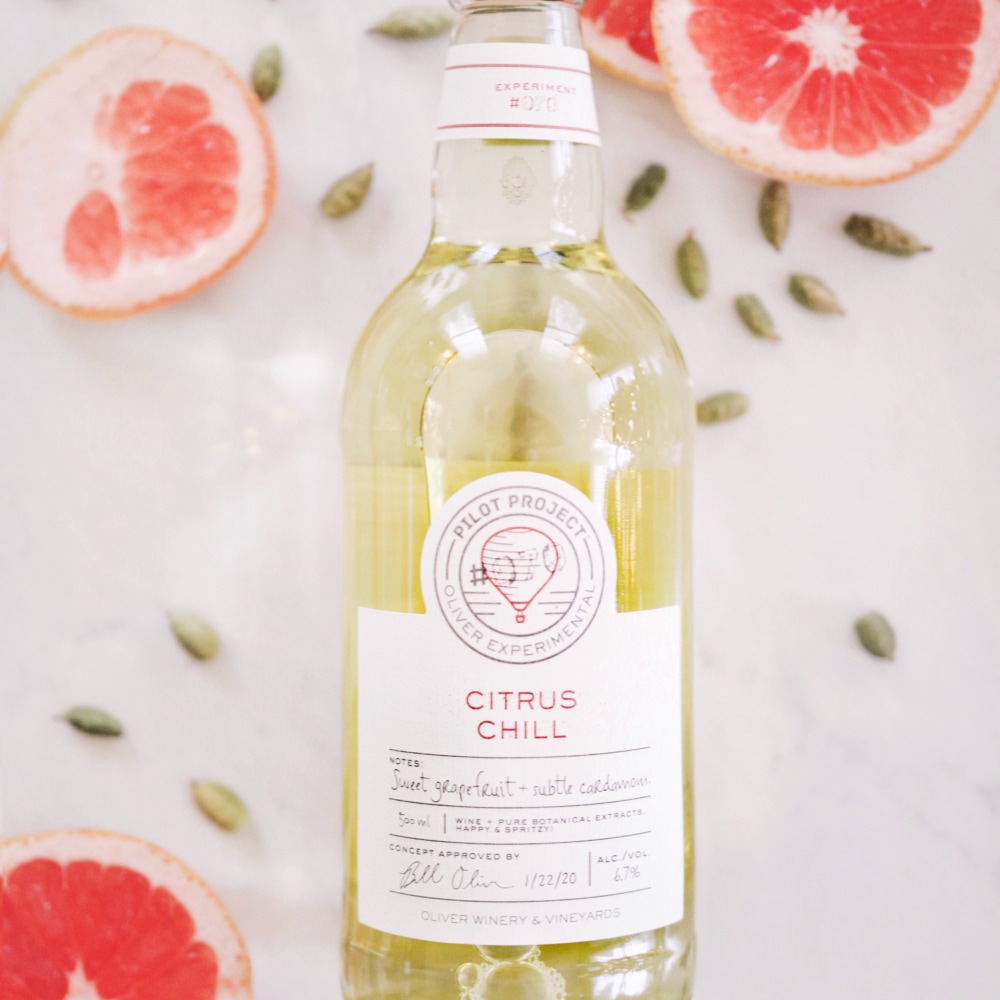 Cardamom seeds and grapefruit slices next to Citrus Chill bottle