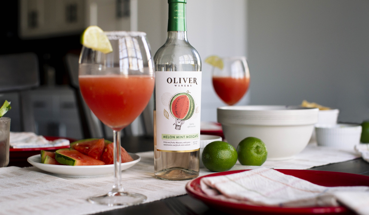 Oliver Winery's new Melon Mint Moscato in a Frosé cocktail, on table with melon and tacos