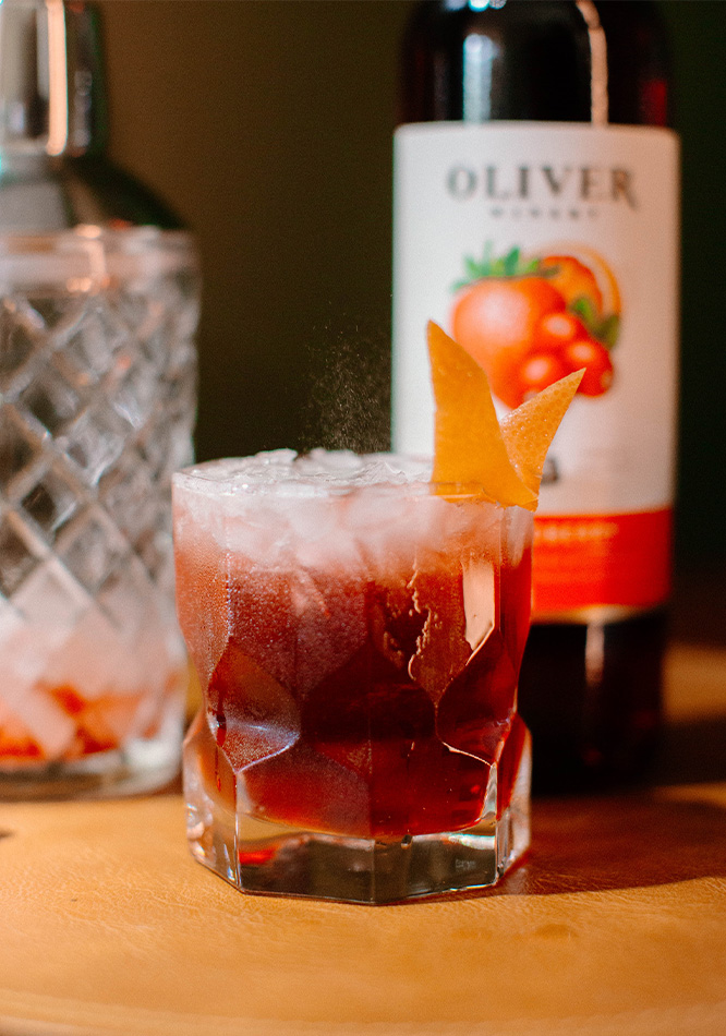 A Cosmoberry wine and bourbon cocktail ready for fall. Autumn flavors of cranberry and blood orange.