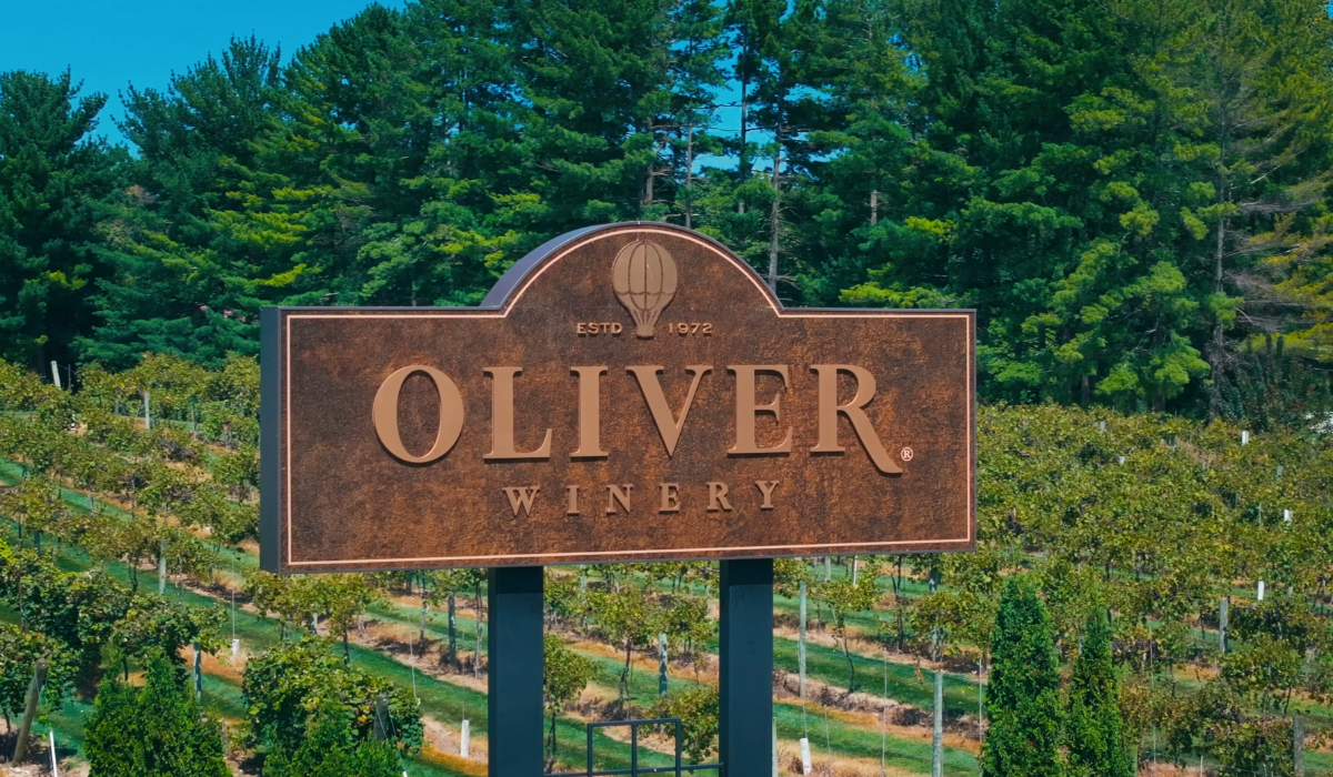 Oliver Winery sign with hot air balloon logo in front of vineyard