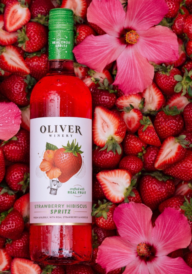 Oliver Strawberry Hibiscus Spritz Overlaid on Strawberry and Hibiscus Flowers