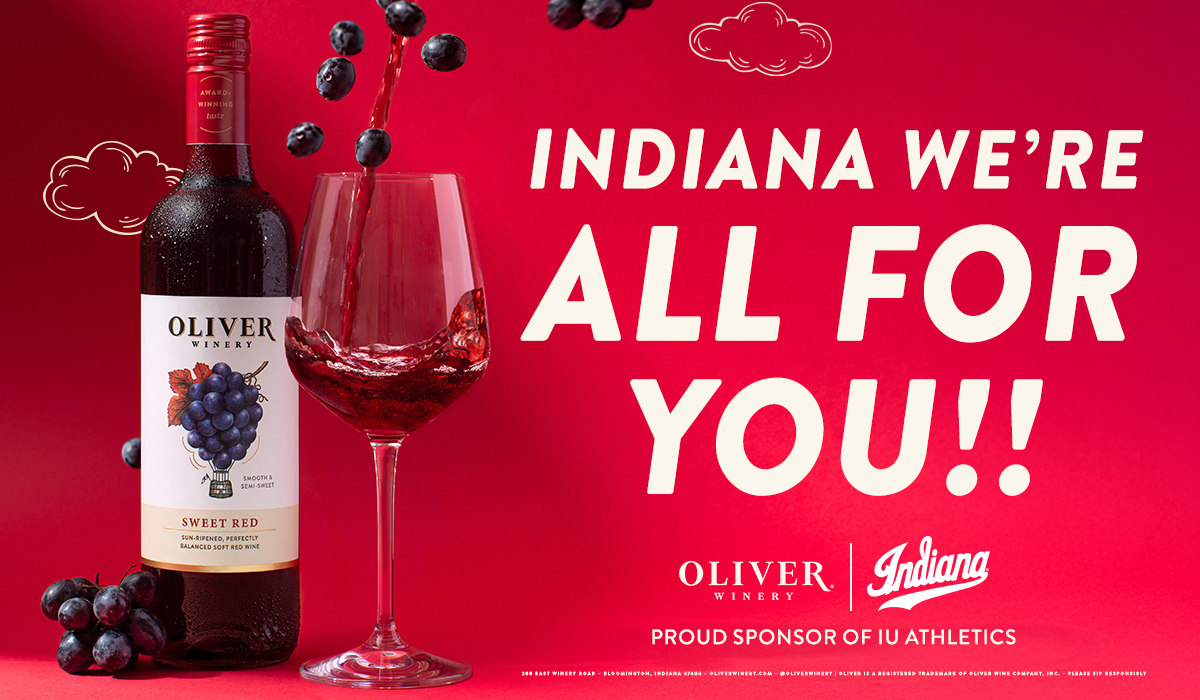 Oliver Sweet Red bottle and a glass of red wine on a crimson background with the message “Indiana, we’re all for you!” and Proud Sponsor of IU Athletics designation. Please sip Responsibly